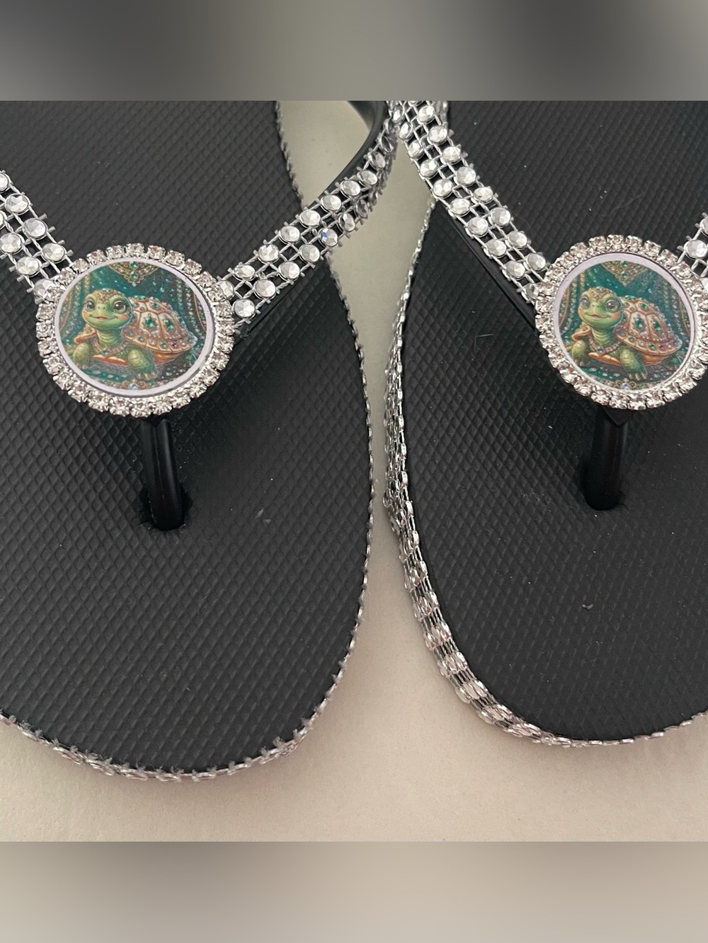 Crystal-Embellished Black Flip Flop Sandals with Turtle Medallion